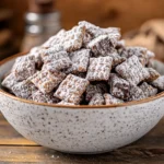 muddy buddy recipe in a homemade bowl with powdered sugar coating